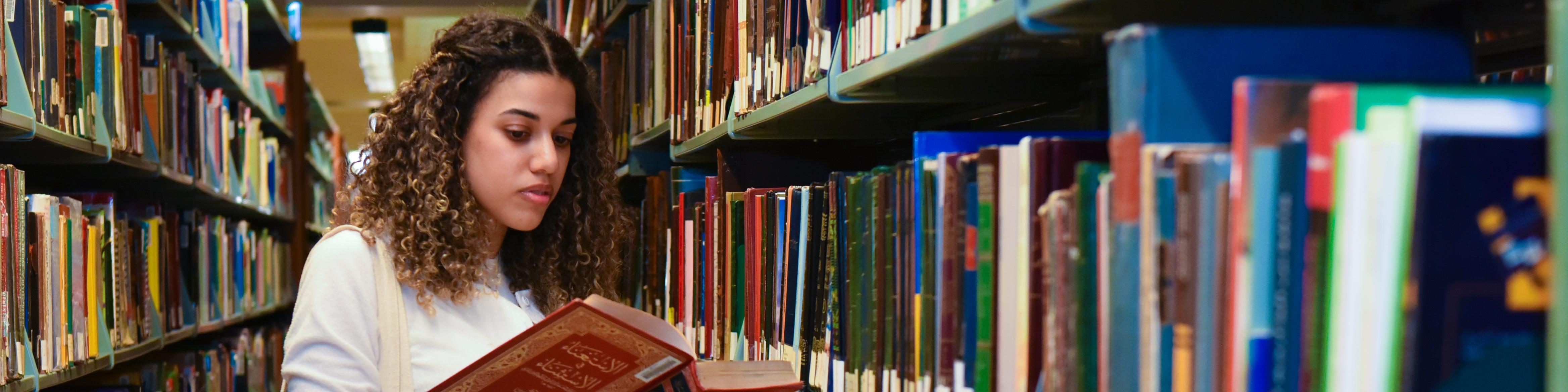 Girl holding a book in library