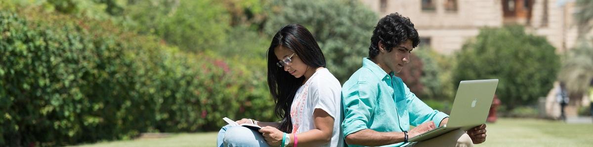 Girl and boy sitting back to back studying