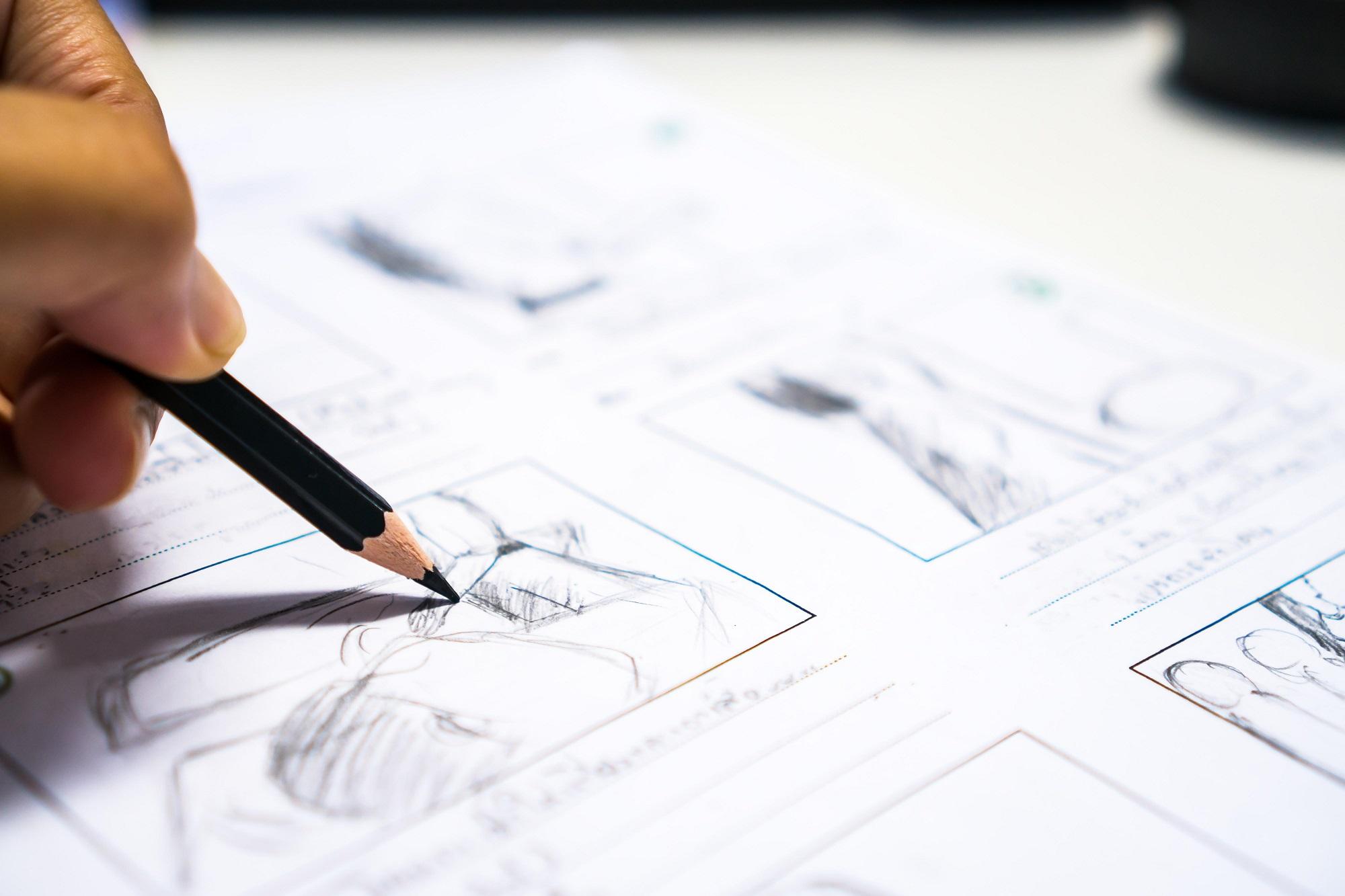 hand holding a pencil writing on a white paper