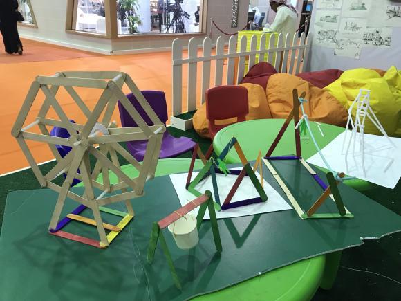 Table with a Ferris wheel made out of colored wooden sticks