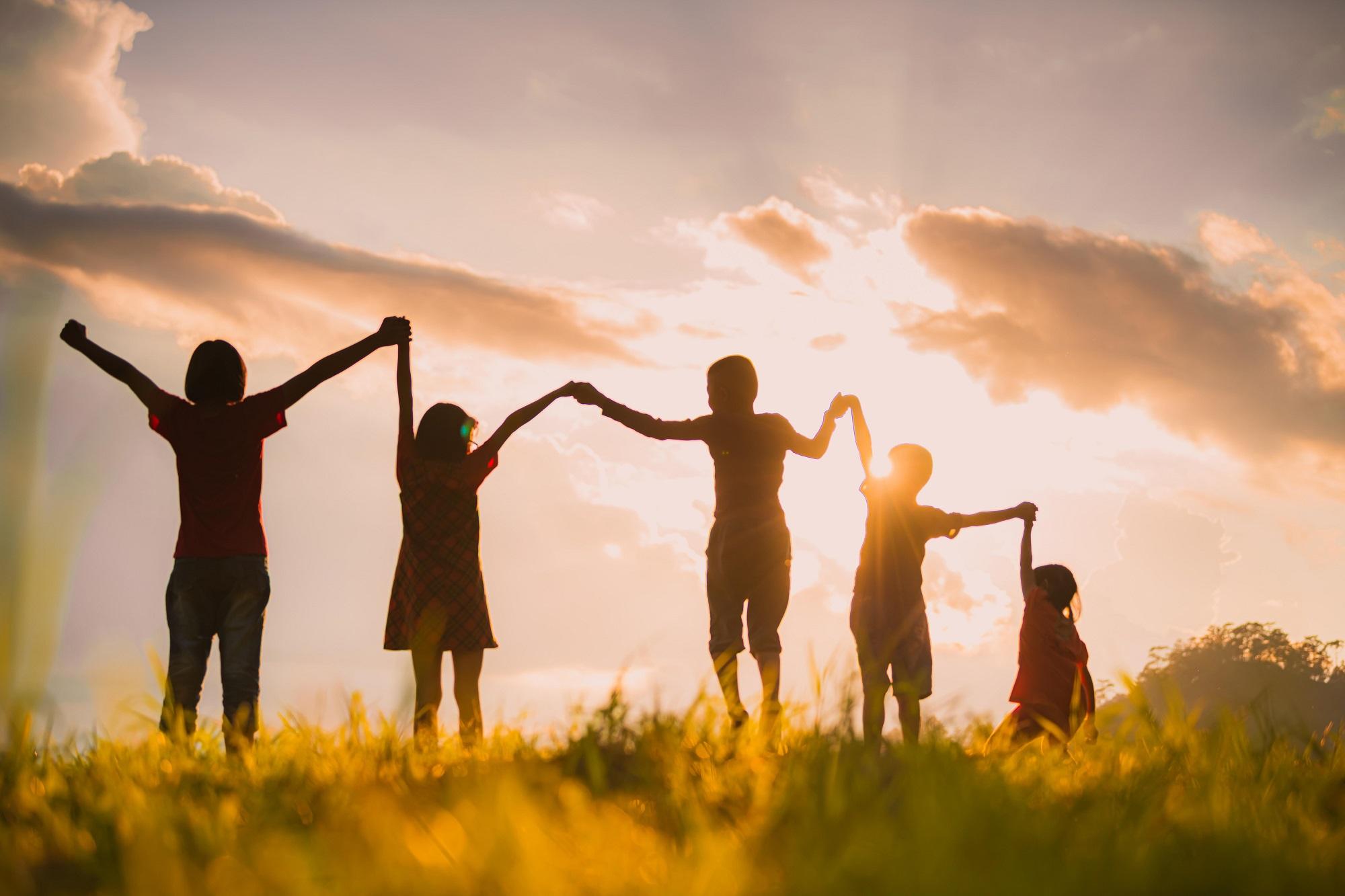 children holding hands in sunset