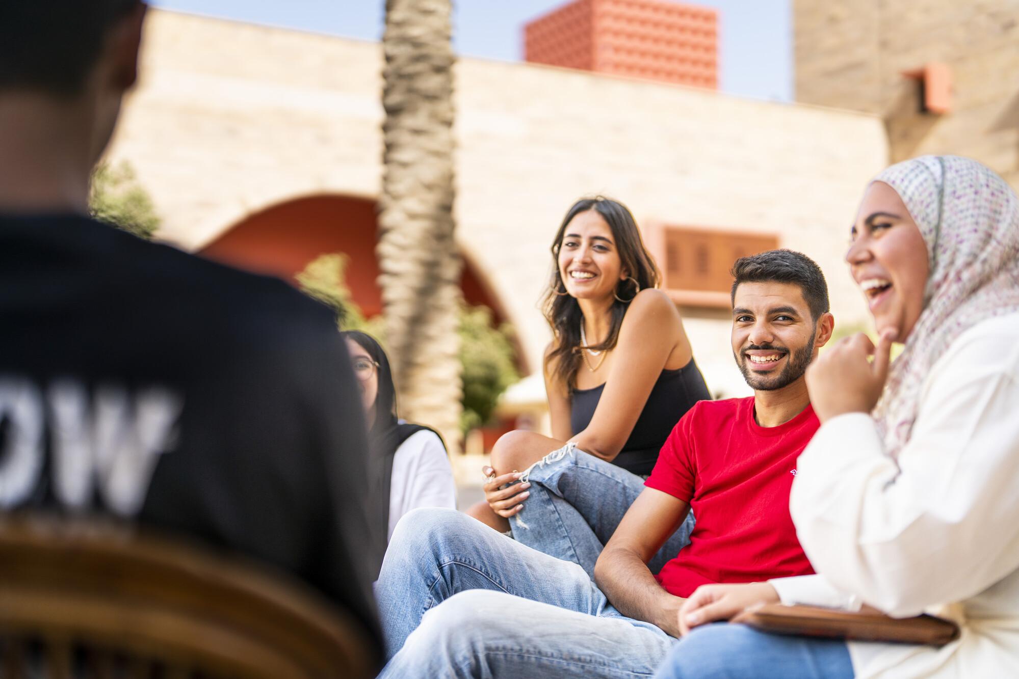group of students sitting together laughing and talking