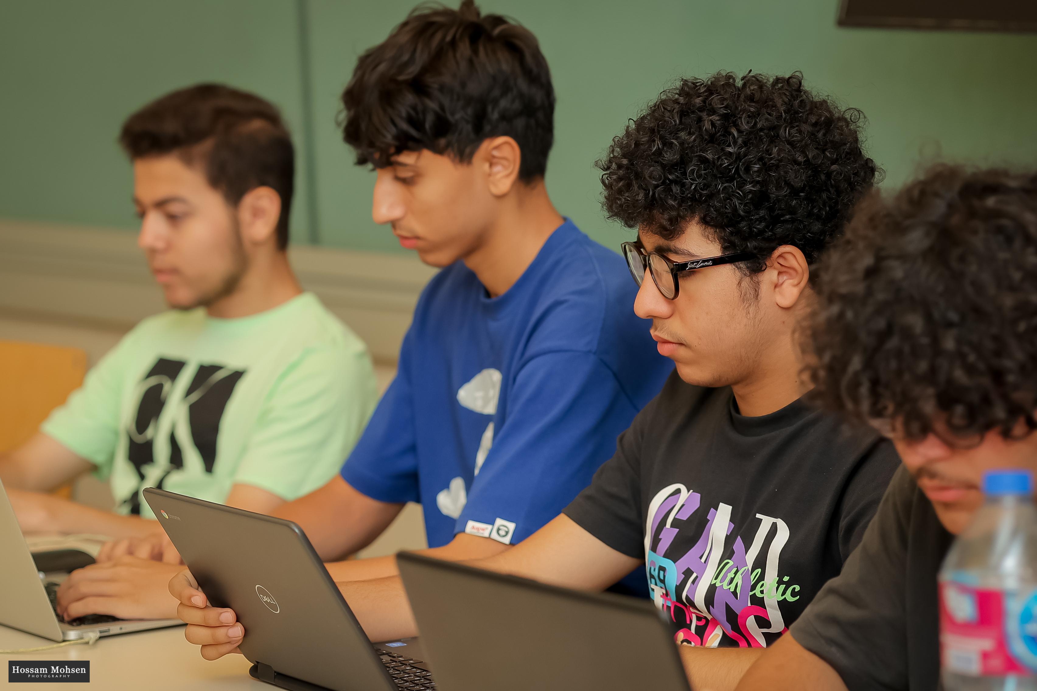 Boys in class working on their laptops