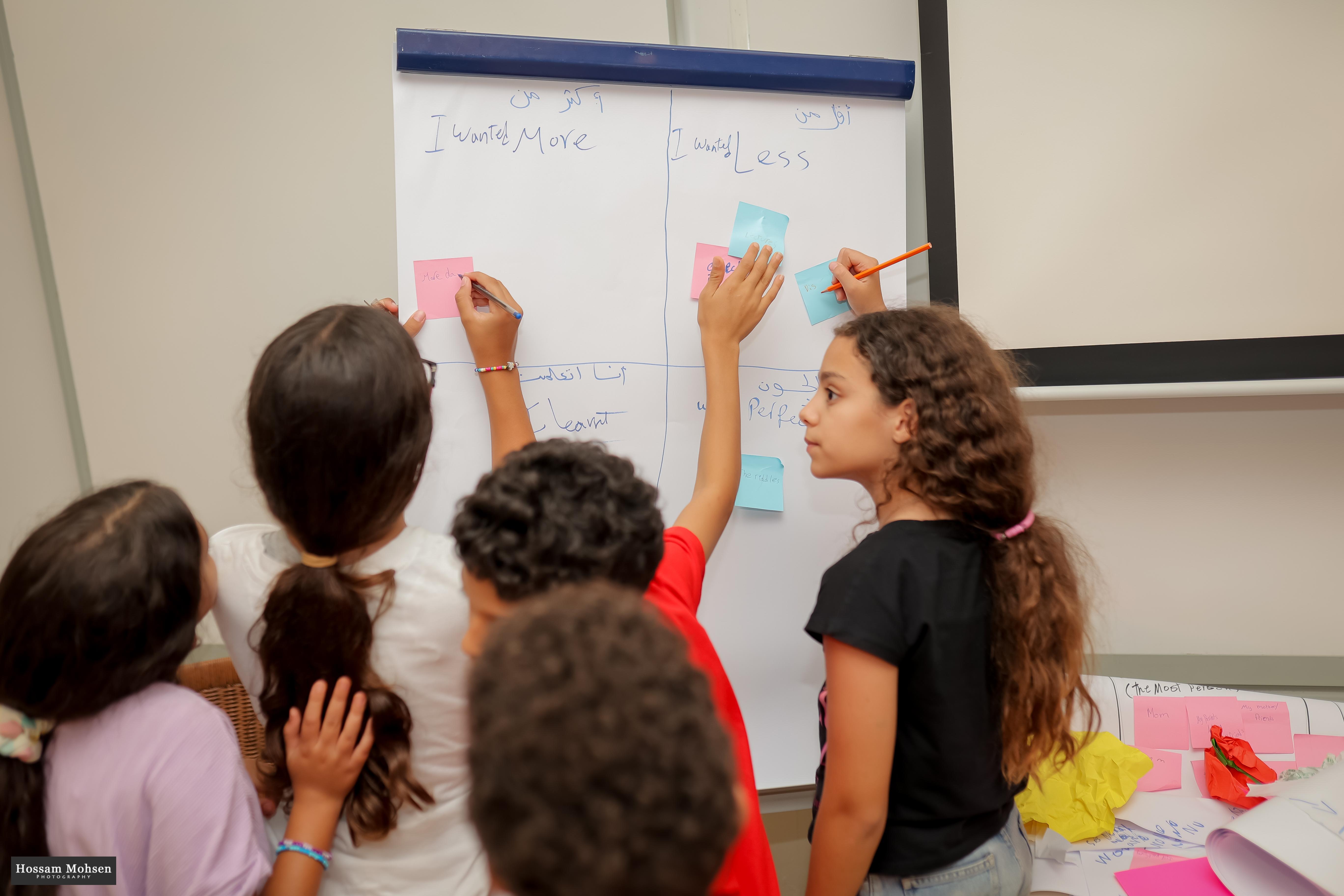 children in class writing on a flipboard