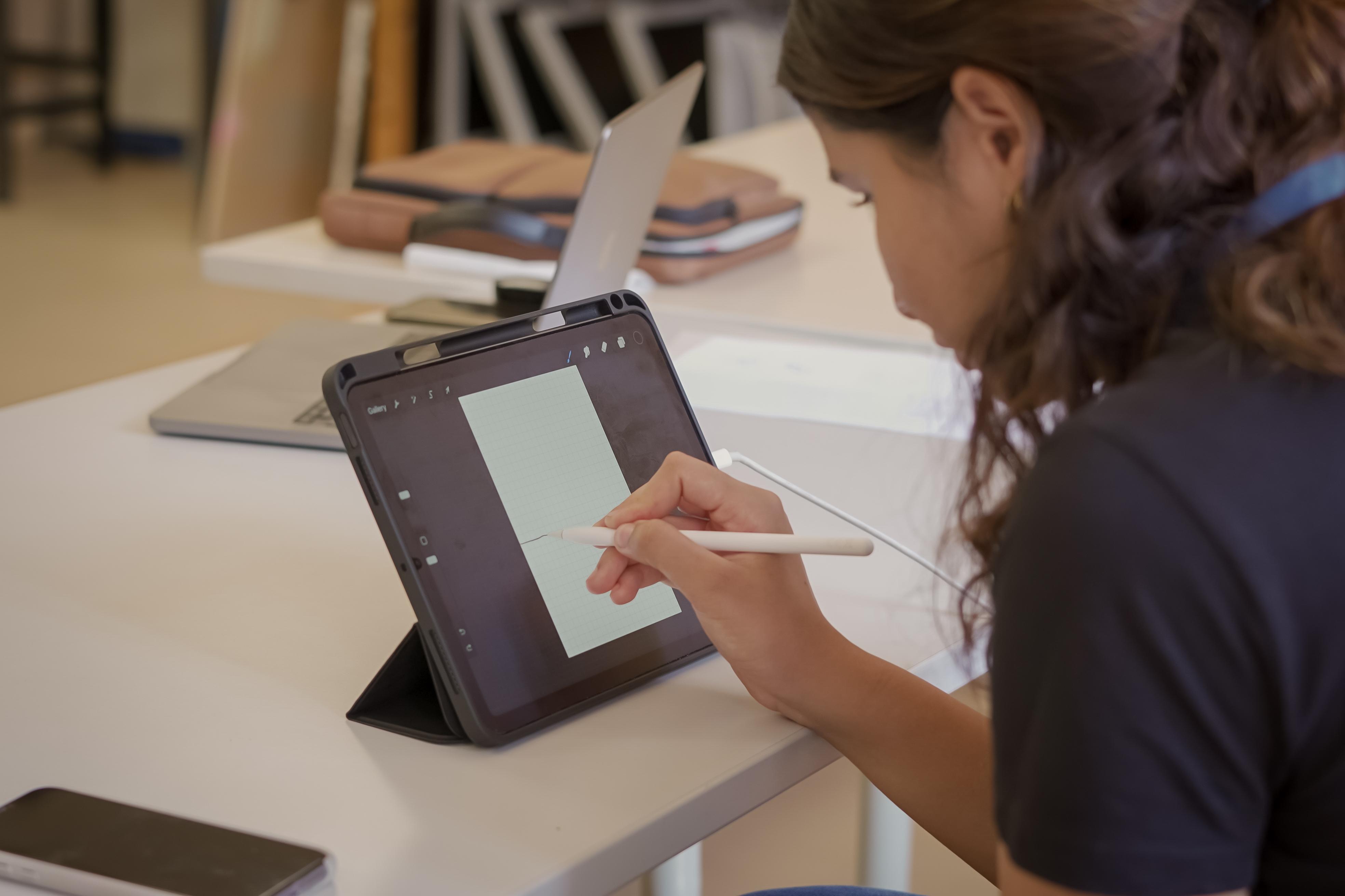 Girl in class working on a design on her iPad