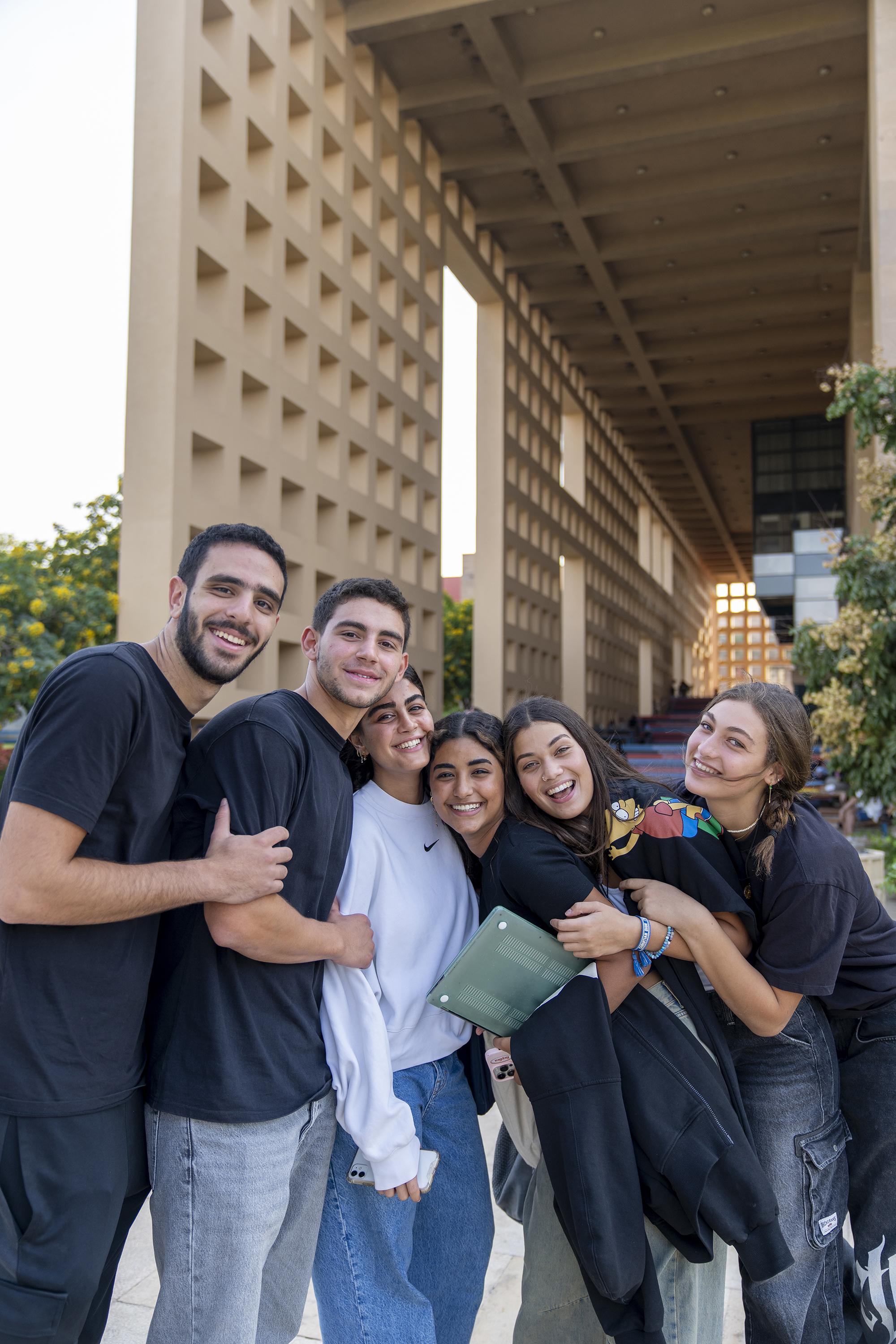 a group photo of boys and girls smiling happily at the camera
