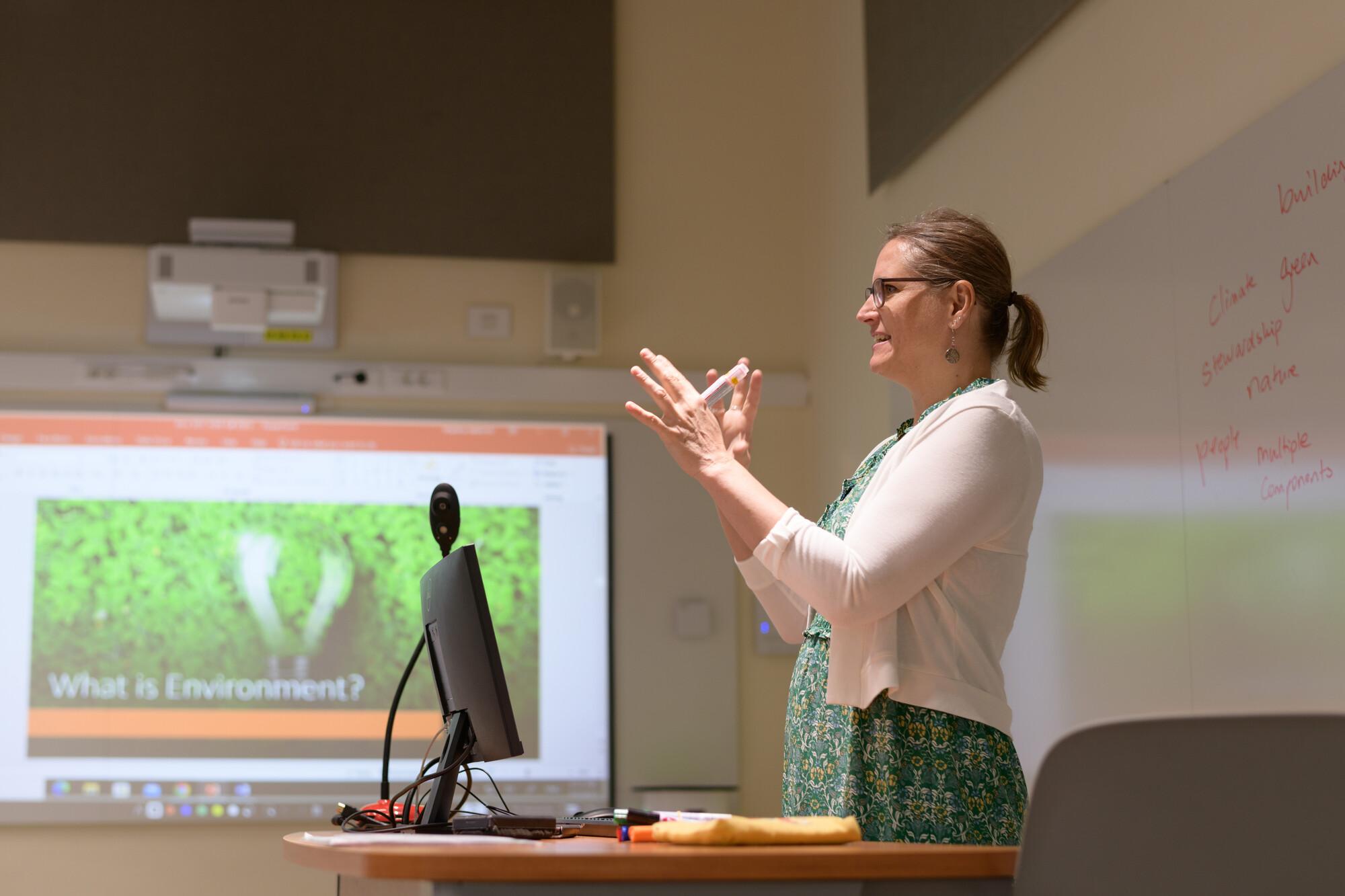  a female faculty member giving a lecture in class