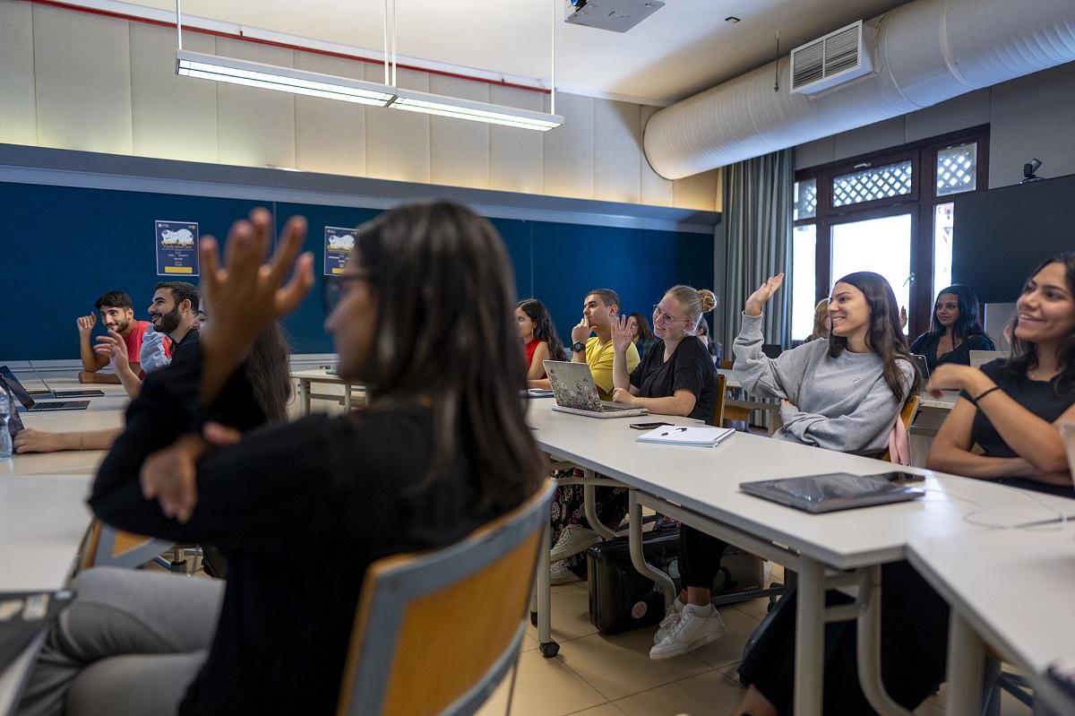 Students raising their hands in class