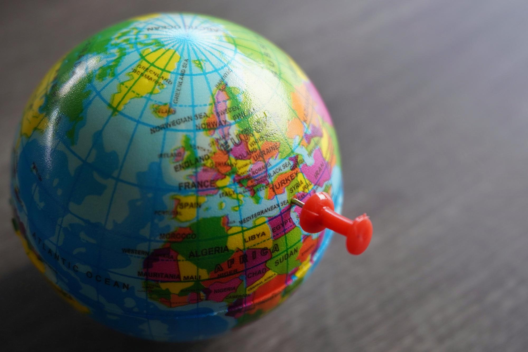 Picture of a side of a globe with a pin pointing to the Middle East