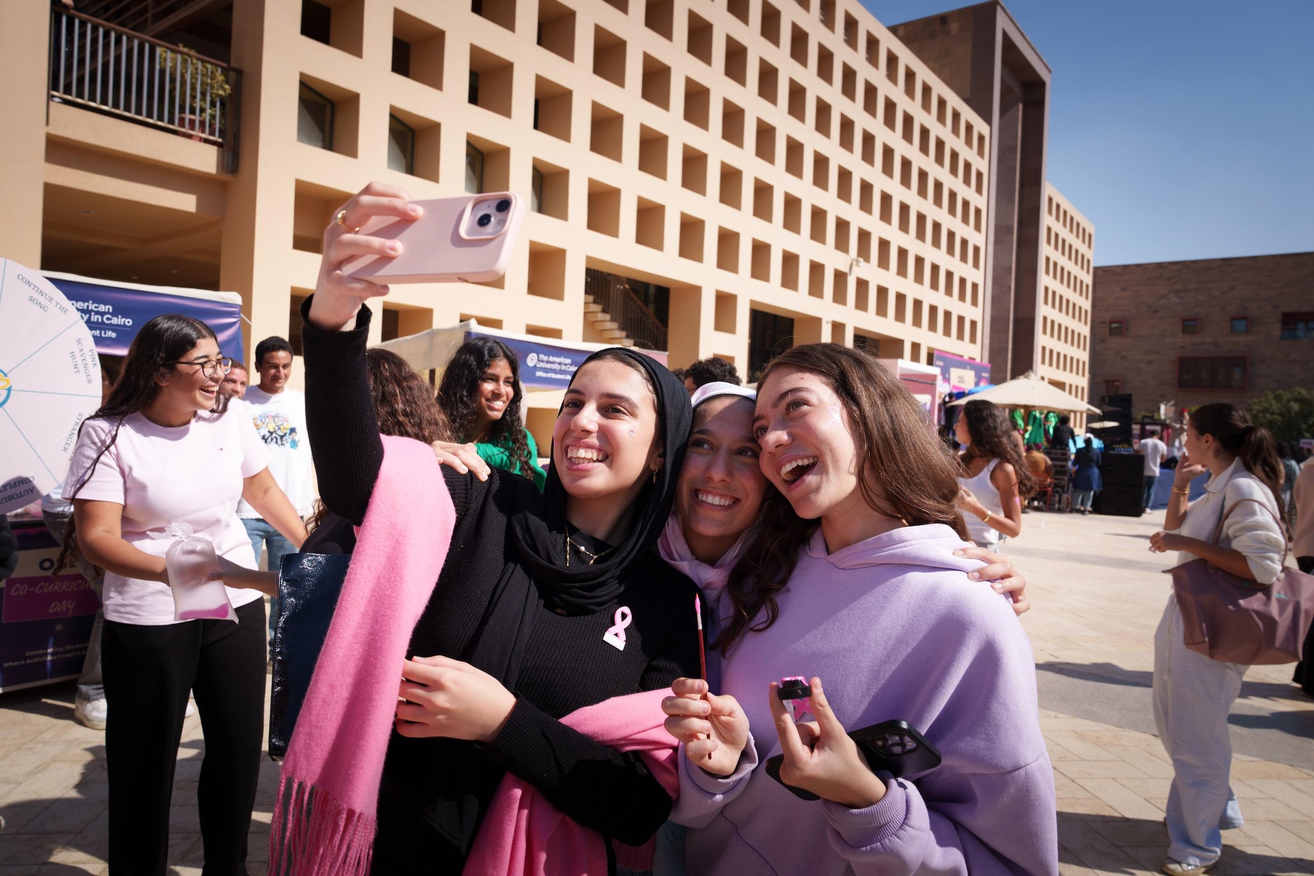 auc girls taking a selfie on campus