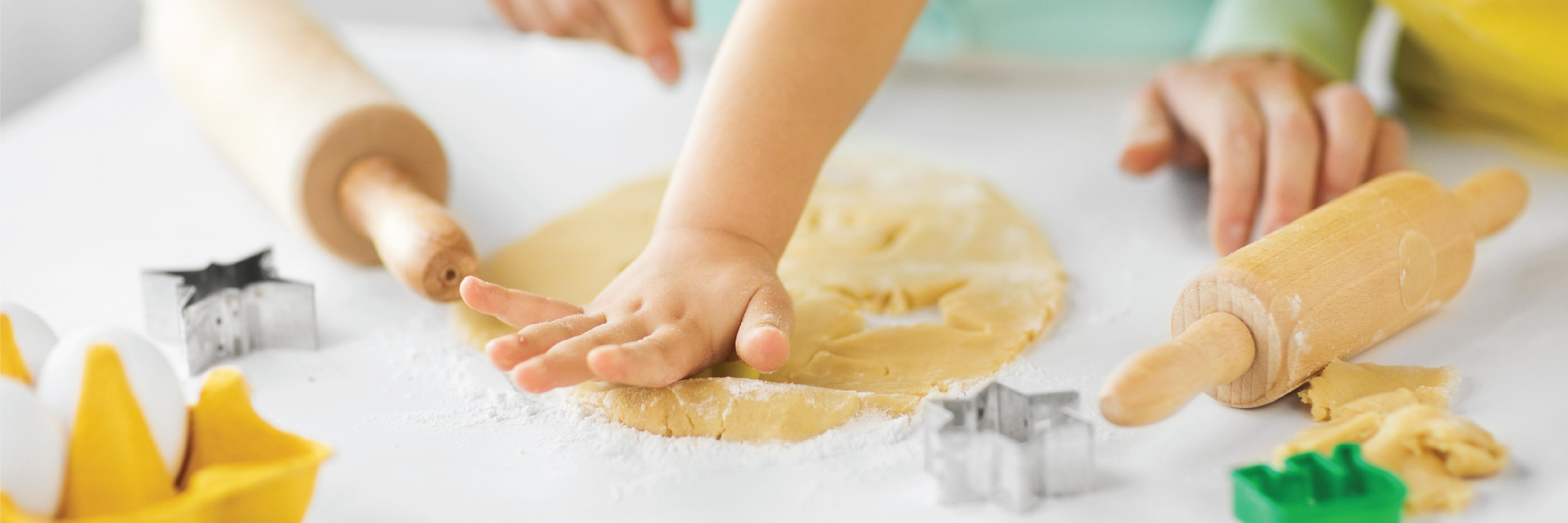 a hand of a baby playing with a playdough