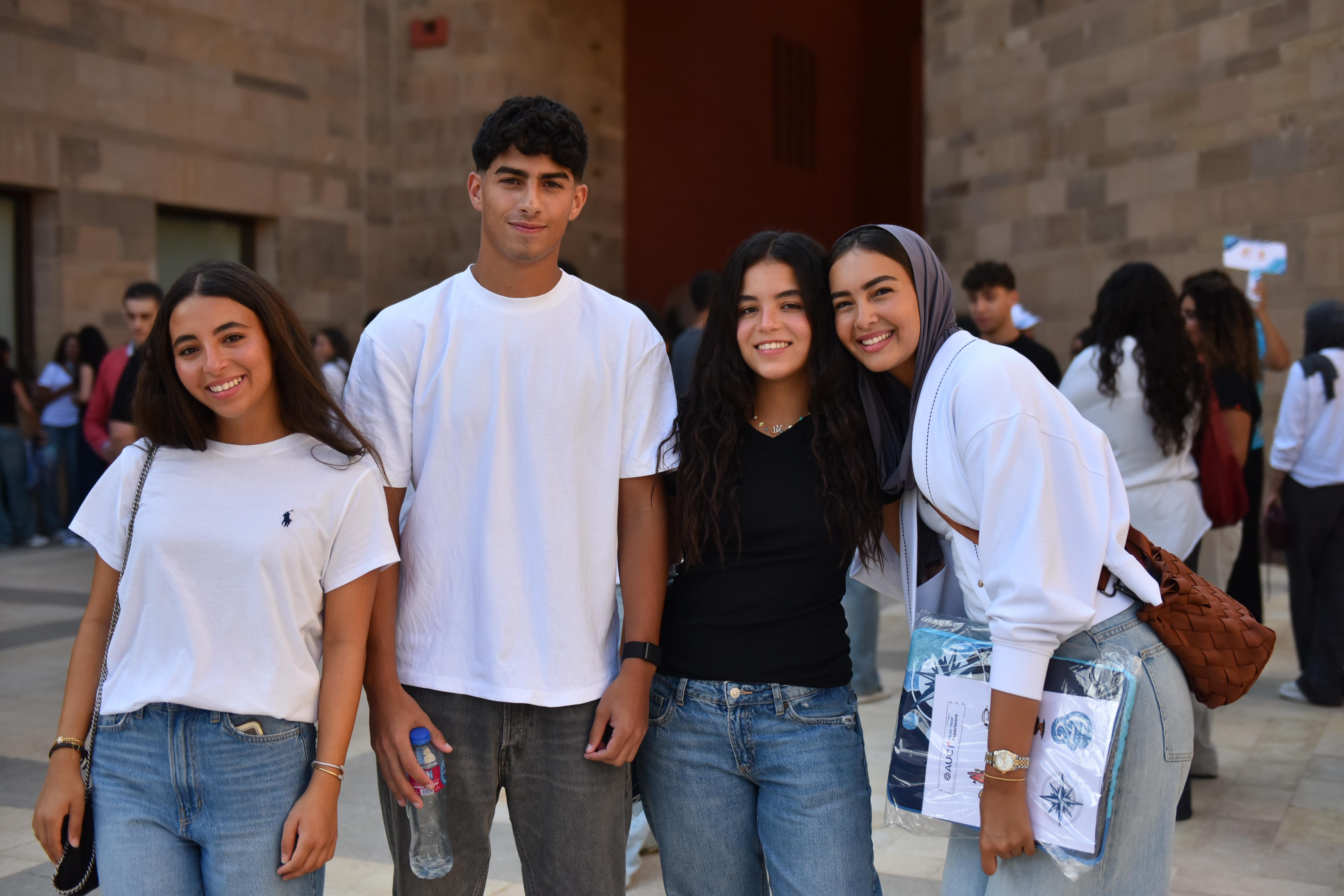 a boy and three girls taking a group picture and smiling