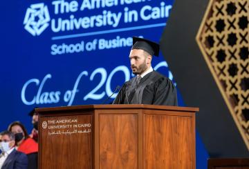 Graduating student standing on podium giving a speech