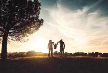 Silhouette of man, woman and child, and a tree representing public health in climate change