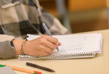 a hand writing in a notebook