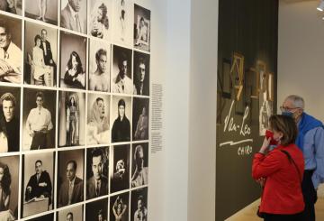 Lady and man looking at wall with art photos