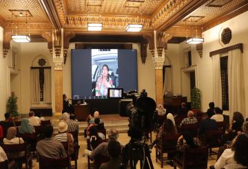 Group of people in a hall watching projector