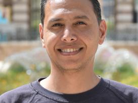 Headshot of a man smiling in an outdoor setting