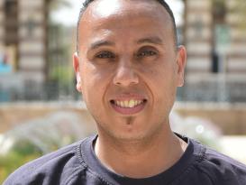 Headshot of a man in an outdoor setting wearing a black tshirt