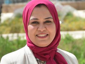 Headshot of a smiling veiled lady in an outdoor setting