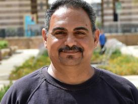 Headshot of a man smiling in an outdoor setting