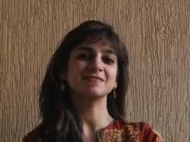 A woman is smiling and crossing her arms