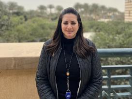 A woman is standing and smiling