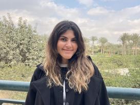 A woman is standing and smiling
