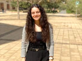 A woman is standing and smiling