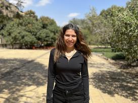 A woman is standing and smiling