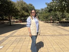 A woman is standing and smiling