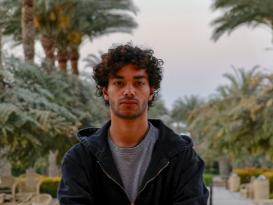 a headshot with a boy with a curly hair 