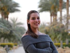a head shot for a girl with a red hair and a grey blouse smiling 