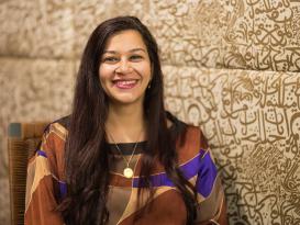 A woman is sitting and smiling
