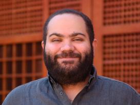 A man is standing and smiling