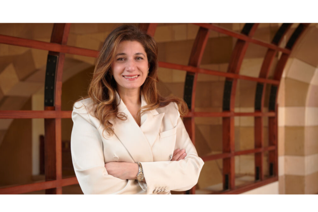 Farah Kashlan stands with her arms crossed in a hallway