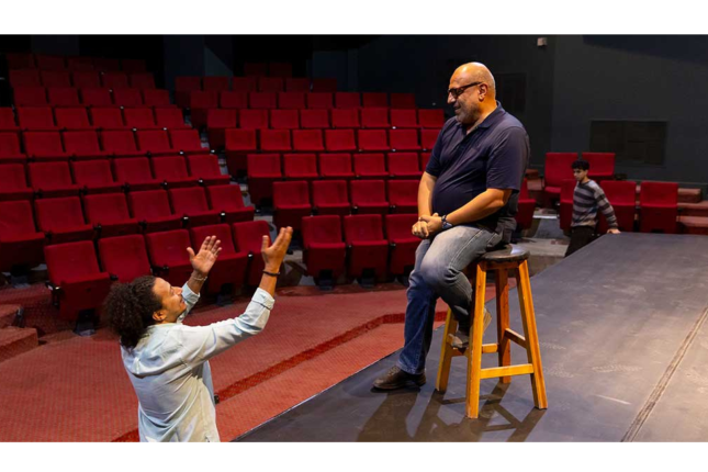 in the theater, an actor emoting to the director