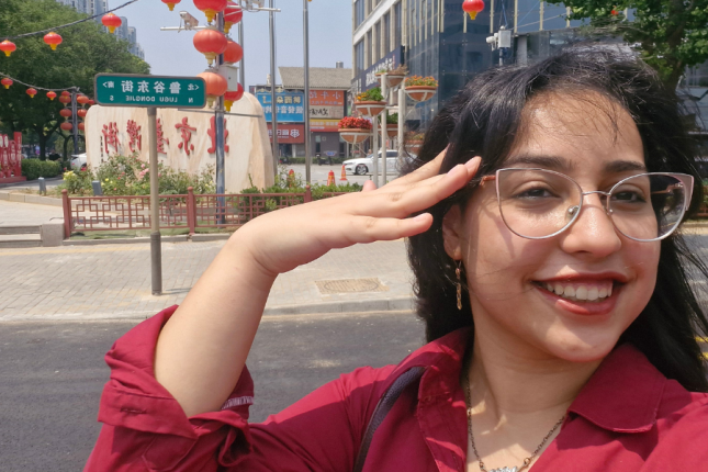 Shahd Younes takes a photo in front of a street