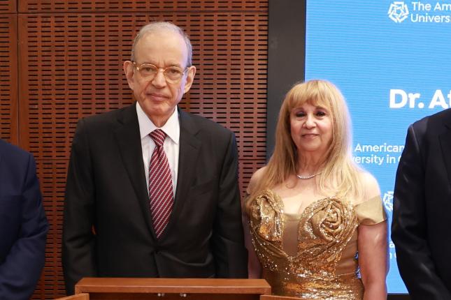Atef Eltoukhy and his wife Fofa stand next to an AUC podium, along with AUC President Ahmad Dallal and Board of Trustees Chairman Mark Turnage