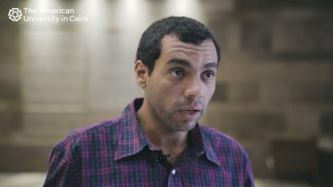 Man wearing purple shirt talking