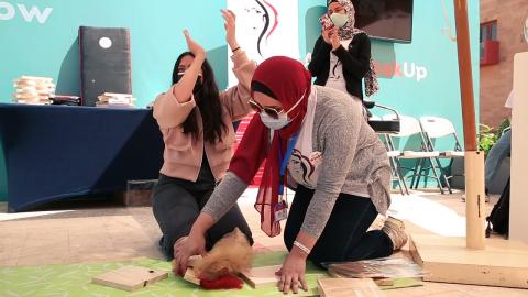 Three masked females, one is holding a mobile phone, one is clapping and the third one is doing floor activities