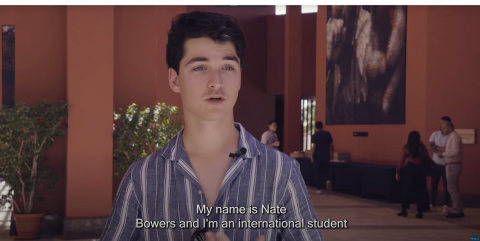 Nate Bowers, international student, talking with people standing in the background