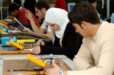 Students sit in a classroom working on brightly colored electronics