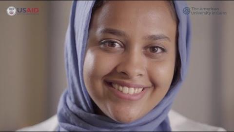 A girl smiling, text reads "The American University in  Cairo and USAID"