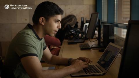 Students sitting down and using their laptops