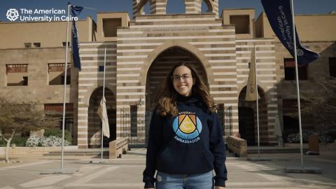 a girl with brown hair wearing a navy hoodie