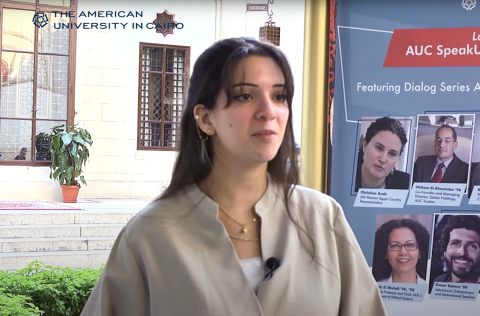 A female talking, seven photos of men and women are displayed behind her, text reads "AUC SpeakUp Dialog Series"