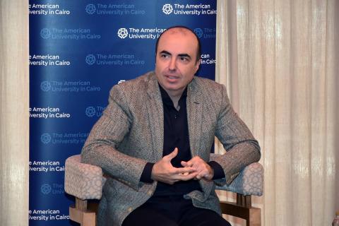 Mohamed Salama sitting on a chair talking to media panelists about his research on healthy aging