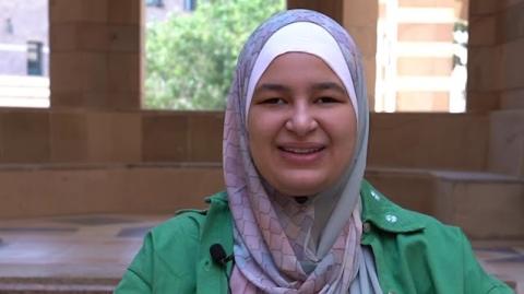 A smiling veiled female student