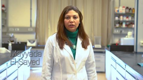 Faculty member Mayyada El Sayed. She is wearing a white lab coat in a lab